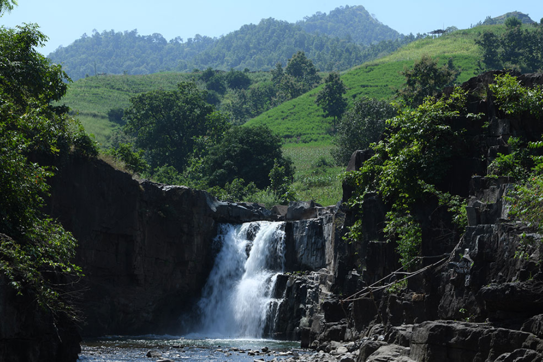Tourists trekking towards Zarwani Waterfall in monsoon season, surrounded by dense forest and misty hills Tourists trekking towards Zarwani Waterfall in monsoon season, surrounded by dense forest and misty hills